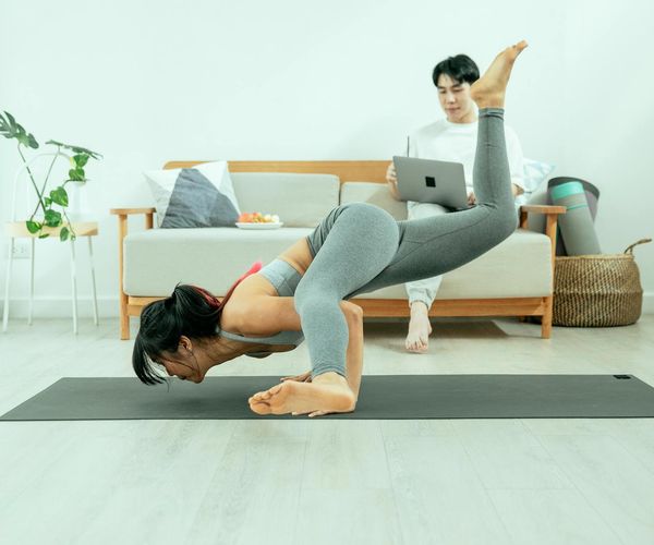 A calm corner of a home with a yoga mat and a plant.