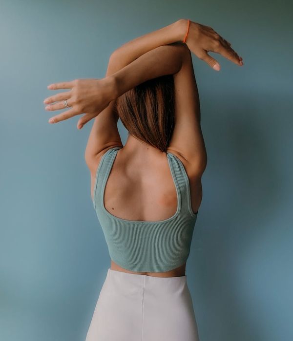 Woman in a graceful yoga pose with lime green light accents.